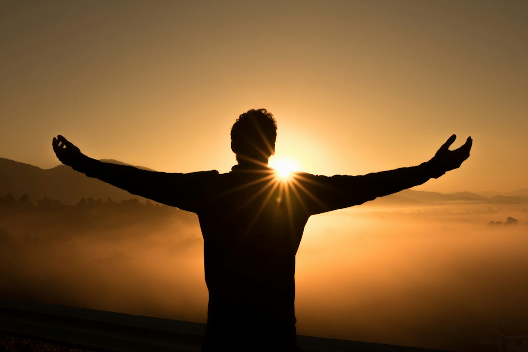 Photo by Zac Durant silhouette photo of man on cliff during sunset